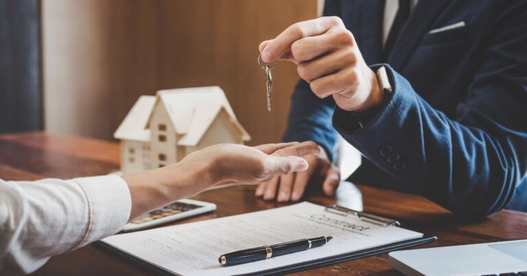 Real estate agent Sales manager holding filing keys to customer after signing rental lease