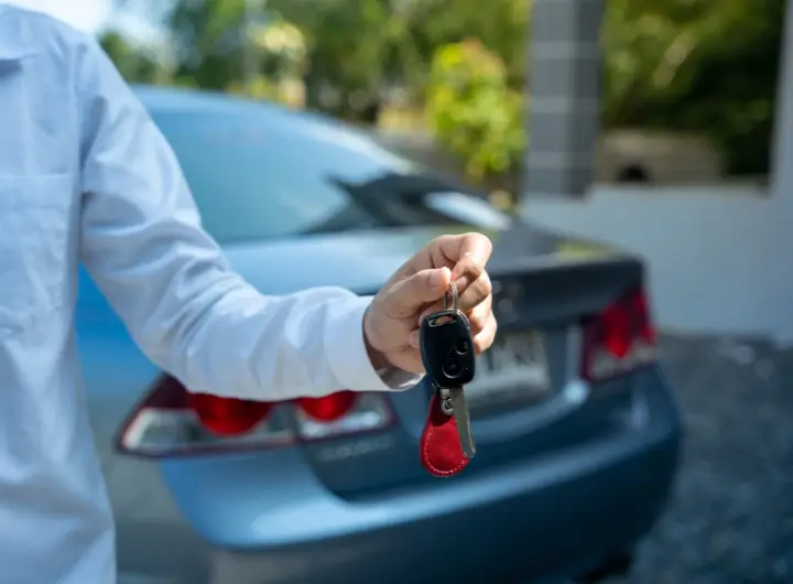 showing a man giving the key for the car deed of sale